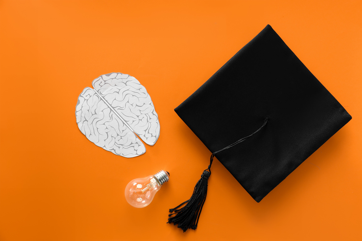 Mortar Board with Paper Brain and Light Bulb on Color Background. Concept of High School Graduation